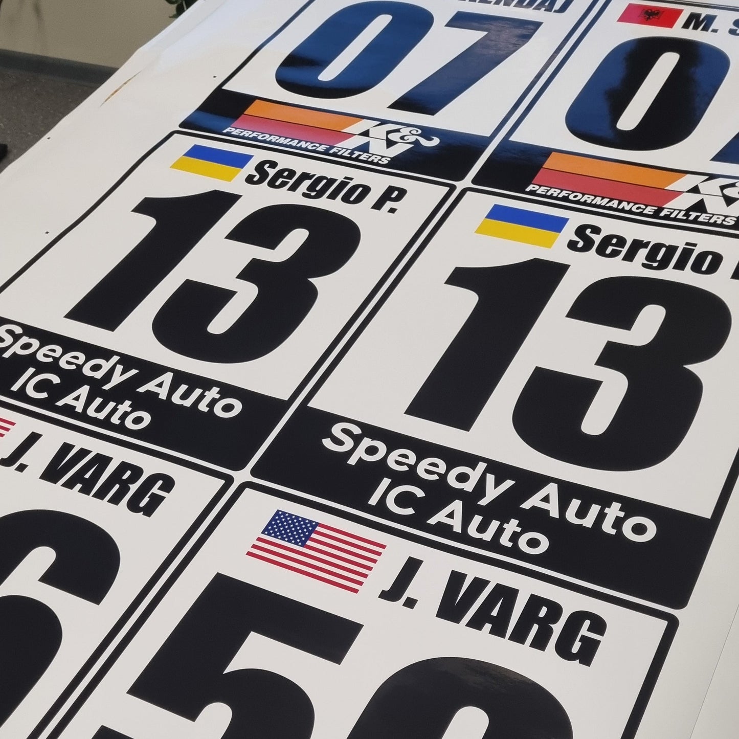 Collection of racing decals with numbers and brand logos on a white background